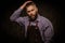 Portrait of stylish barber with beard and professional tools isolated on a dark background.