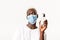 Portrait of stylish handsome african-american blond male in medical mask, showing hand sanitizer, advice using