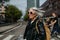 Portrait of stylish mature woman with gray hair on city street. Older woman in sunglasses crossing a road on pedestrian