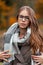 Portrait of a stylish pretty young hipster woman with blue eyes in glasses in a vintage knitted sweater in an autumn trendy coat