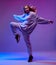 Portrait of a stylish young girl, cool dancing in a hoodie and with developing hair, on a neon background.