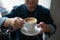 Portrait of stylish young man with cup of coffee.. Cappuchino or latte coffe in a white cup on a dark background.