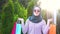 Portrait of a stylish young muslim woman with bags in her hands after shopping