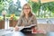 Portrait of successful beautiful middle-aged blonde woman in summer outdoor restaurant