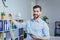 Portrait of a successful business founder, a man looks at the camera and smiles at a white board for notes, holding a tablet,