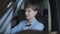 Portrait of a successful cute young girl with short dark hair dressed in a stylish suit sitting in a luxury car. Motor