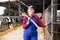 Portrait of successful european female farmer posing in cowshed