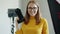 Portrait of successful female photographer beautiful woman holding camera in studio