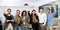 Portrait of successful group of young Asian business persons raising hands and smiling and looking at camera in the office