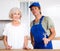 Portrait of successful plumber together with an elderly landlady in kitchen