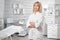 Portrait of successful professional doctor cosmetologist dermatologist woman in beauty salon smiling in white medical clothes