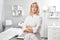 Portrait of successful professional doctor cosmetologist dermatologist woman in her beauty salon smiling in white medical clothes