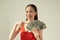 Portrait of successful woman 20s holding lots of money dollar banknotes isolated over bright background