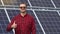 Portrait of a successful young engineer on the background of a solar power station. An engineer checks solar panels