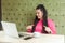 Portrait of suprised young girl with black dreadlocks hairstyle in pink blouse are sitting alone in cafe and having new proposal