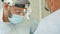 Portrait of a surgeon, in medical mask and surgical loupes, performs a surgery in hospital operating room.