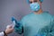 Portrait of a surgeon in a sterile dressing gown and mask, with gloves on, looking at the camera, forbidding him to hand him a