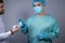 Portrait of a surgeon in a sterile dressing gown and mask, with gloves on, looking at the camera, forbidding him to hand him a