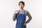 Portrait of surprised and amazed young caucasian guy in apron pointing at himself and looking disbelief, gasping drop