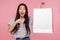 Portrait of surprised beautiful asian woman expressing amazement and pointing to shopping bag with white copy space