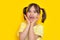 Portrait of surprised exited cute girl with missing baby tooth smile having fun over yellow