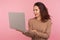 Portrait of surprised freelancer working on computer. Amazed young woman in casual sweater reading shocking message