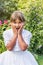 Portrait of surprised little girl in white bridesmaid clothes