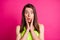 Portrait of surprised nice brunette long straight hair young lady hands cheeks wear lime top  on vivid pink