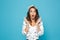 Portrait of surprised or shocked woman 20s wearing casual clothing raising up hands at face, isolated over blue background