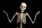 Portrait of surprised skeleton standing over black background.