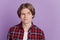 Portrait of suspicious distrustful guy raise eyebrow look side empty space on violet background