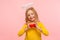 Portrait of sweet lovely angelic little girl with halo over head holding toy hearts and looking at camera