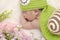 Portrait of sweet newborn baby in knitted snail costume