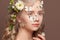 Portrait of sweet perfect young woman with healthy blonde curly hair, white spring flowers and  butterfly on brown background