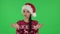 Portrait of sweety girl in Santa Claus hat is clapping her hands indifferent. Green screen