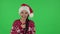 Portrait of sweety girl in Santa Claus hat communicates with someone in a friendly manner. Green screen
