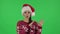 Portrait of sweety girl in Santa Claus hat is dancing funny. Green screen