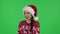 Portrait of sweety girl in Santa Claus hat is having fun. Green screen
