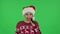 Portrait of sweety girl in Santa Claus hat is laughing and having fun. Green screen