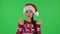 Portrait of sweety girl in Santa Claus hat is waving hand and showing gesture come here. Green screen