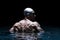 Portrait of a swimmer on a black background. The concept of swimming and water games. Back view