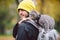 Portrait of tall young Caucasian happy man outdoor playing with gray funny handsome kitten sits on his back on transparent cat