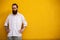 Portrait of tattooed bearded hipster on yellow wall