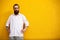 Portrait of tattooed bearded hipster on yellow wall