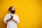 Portrait of tattooed bearded hipster on yellow wall