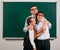 Portrait of a teacher, schoolboy and schoolgirl with old fashioned eyeglasses posing on blackboard background - back to school and