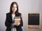 Portrait of the teacher with textbooks and Board in the background