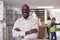 Portrait Of Team Male Leader In Warehouse With Staff Picking Items From Shelves In Background