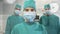 Portrait of team of surgeons in operation theatre at hospital against time-lapse of people walking