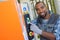 Portrait technician pointing to panel on machine in factory